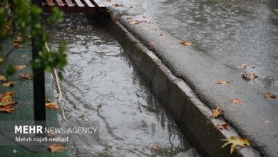 عکسی از یک خودرو در حال رانندگی در جاده‌ای لغزنده در استان ایلام با باران شدید.